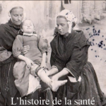 "Black and white photo of two nurses caring for an injured girl."